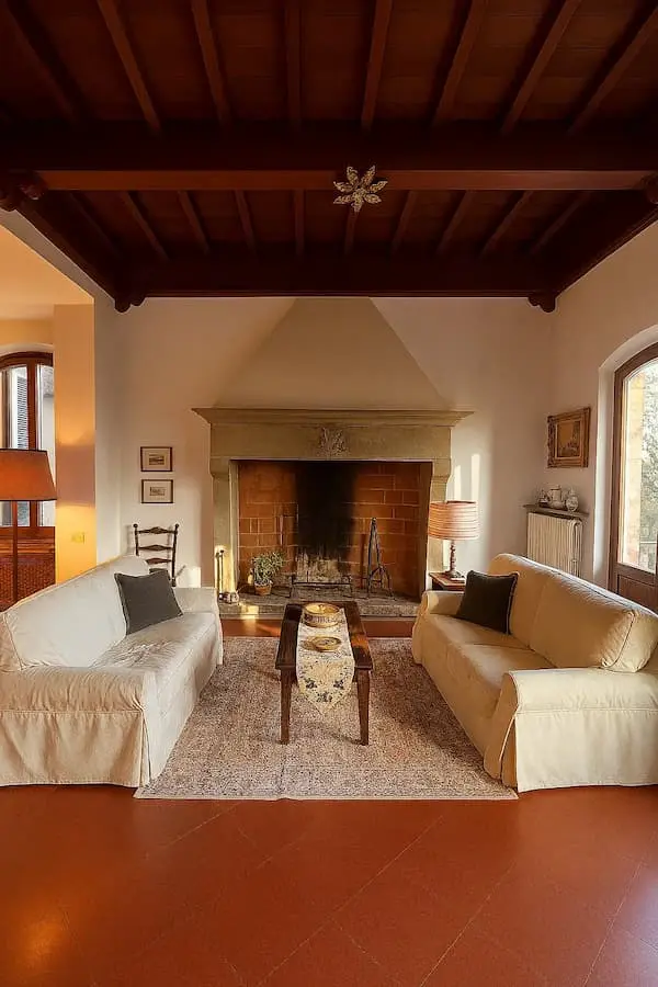 Living room with traditional fireplace and wooden ceiling in a private Tuscan home for sale directly by the owners